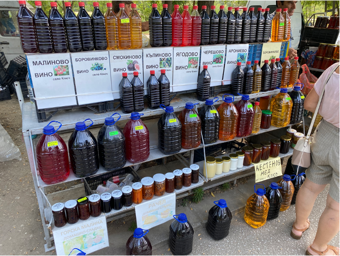 Bottles of fruit wine and preserves at a roadside stall near Rupite